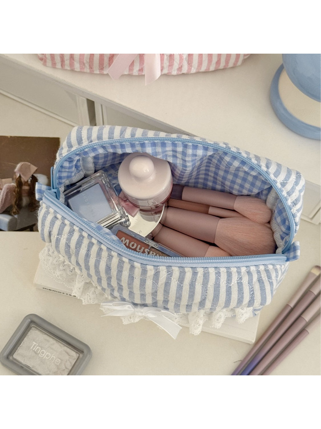 Close-up of Cosbai cosmetic pouch showing lace trim and striped fabric