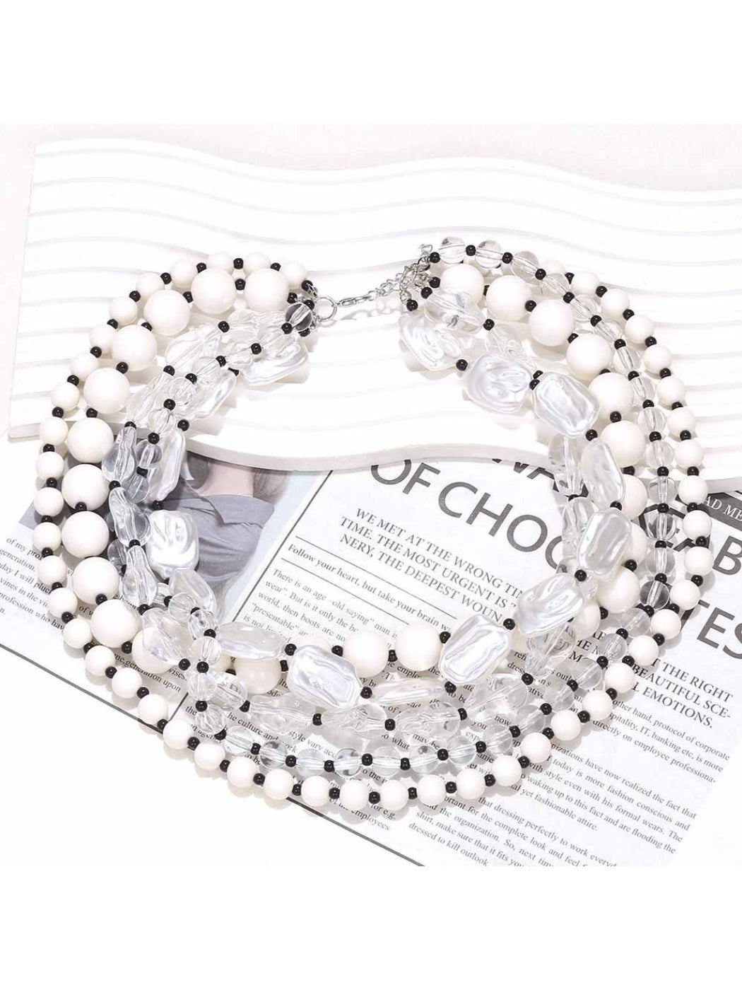 Neckit layered bead necklace with crystal detail displayed on a black surface