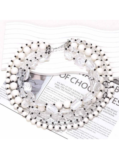 Neckit layered bead necklace with crystal detail displayed on a black surface
