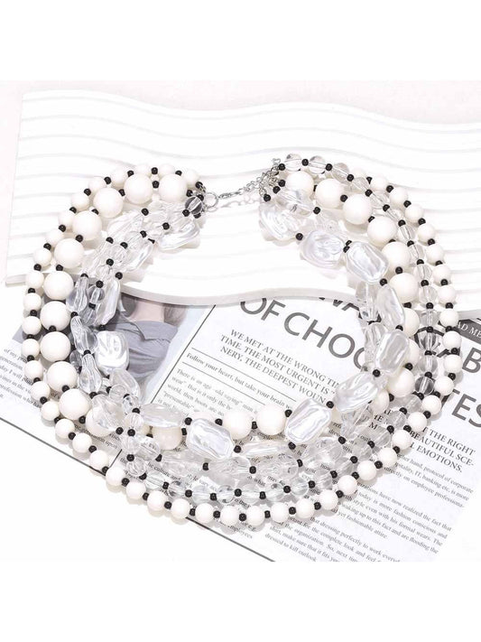 Neckit layered bead necklace with crystal detail displayed on a black surface