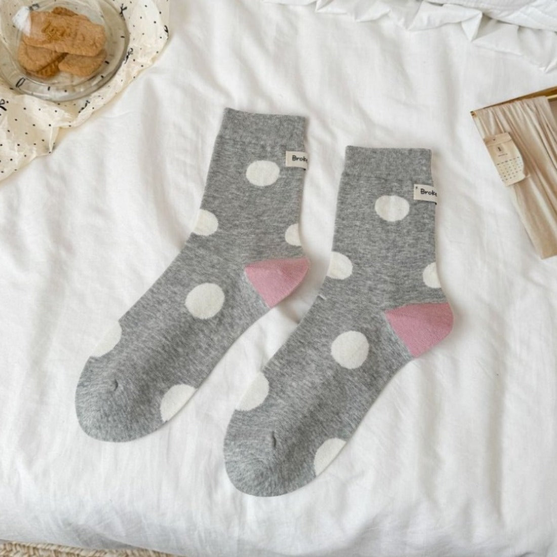 Side view of Rufia contrast heel socks featuring black dots on white background