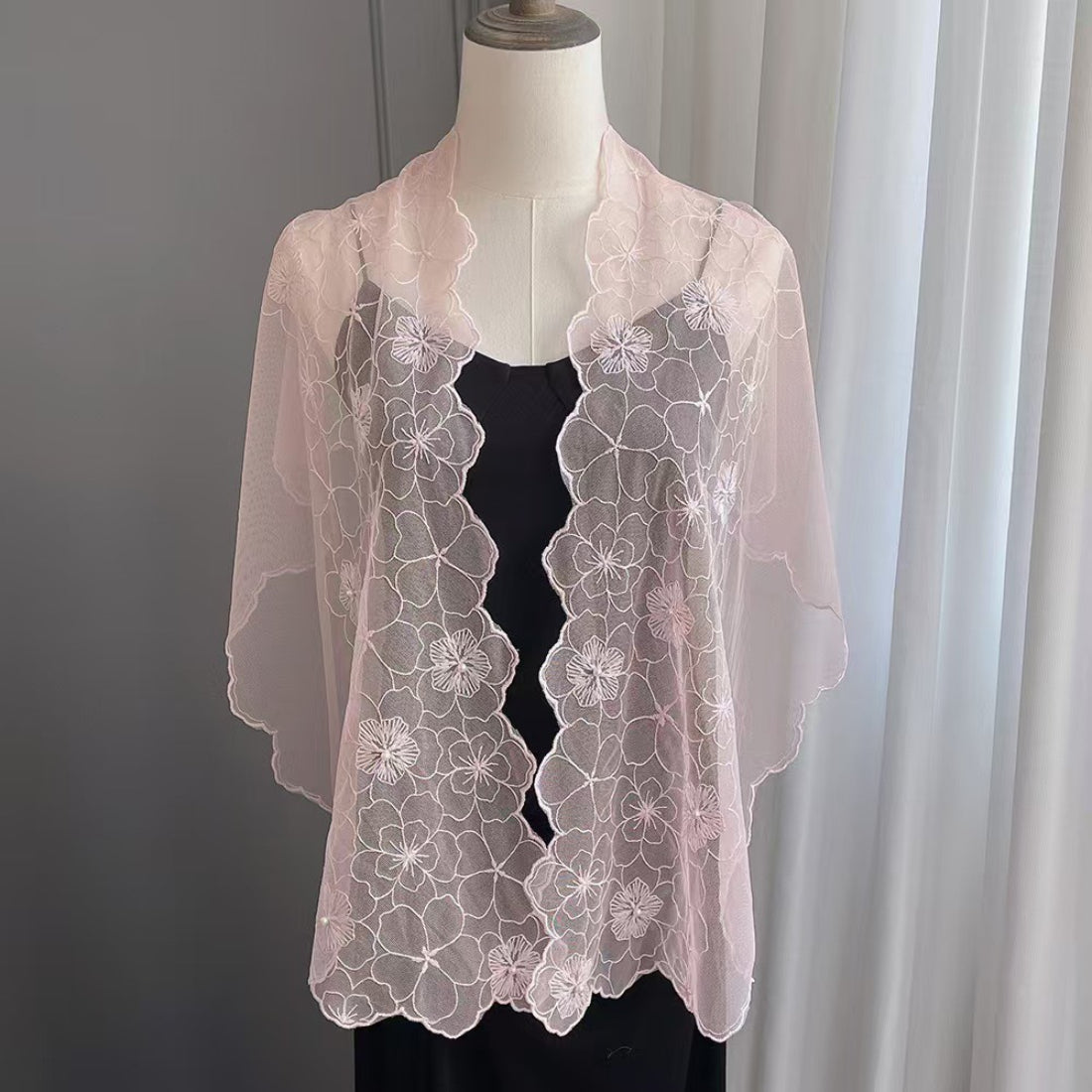 Close-up of floral lace scarf with pearl trim in soft pastel colors