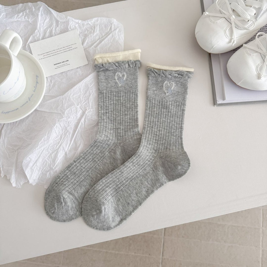 Stack of Rufia crew socks in various neutral colors folded neatly