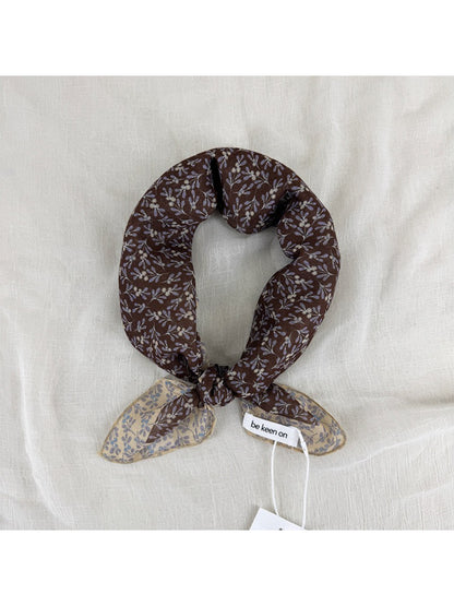Close-up of Scarvii scarf fabric with small floral patterns and detailed border