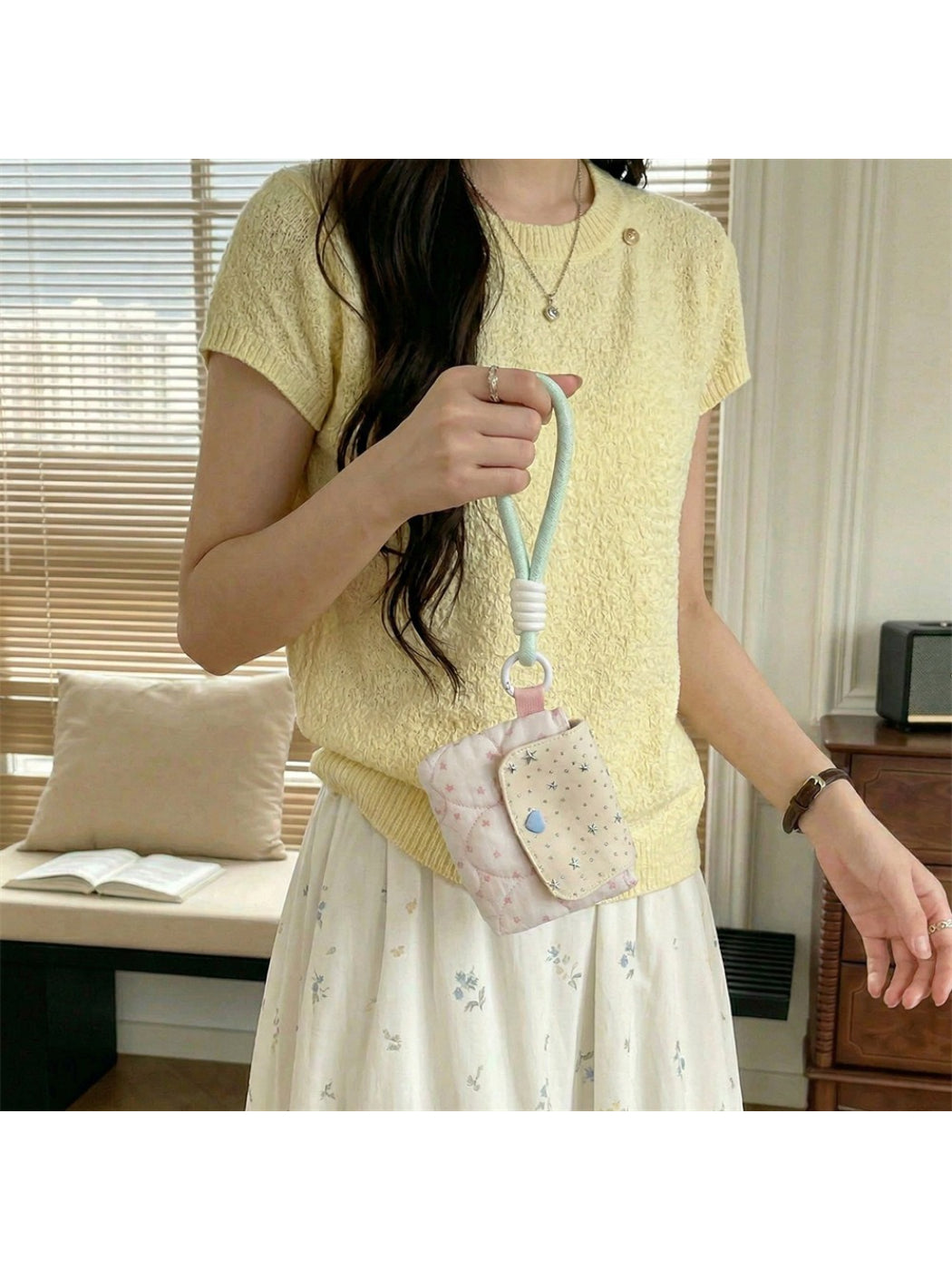 Cosbai mini wrist pouch placed on a white surface with wrist strap extended