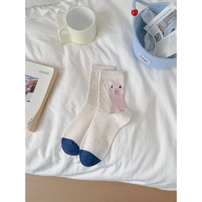 Model sitting with Rufia cat knit crew socks visible above shoes