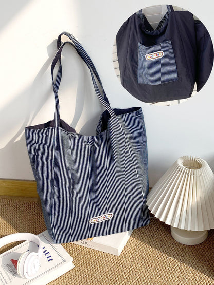 Cosbai striped reversible tote bag shown flat with handles extended