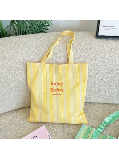 Close-up of Cosbai tote bag showing black handles and striped fabric detail