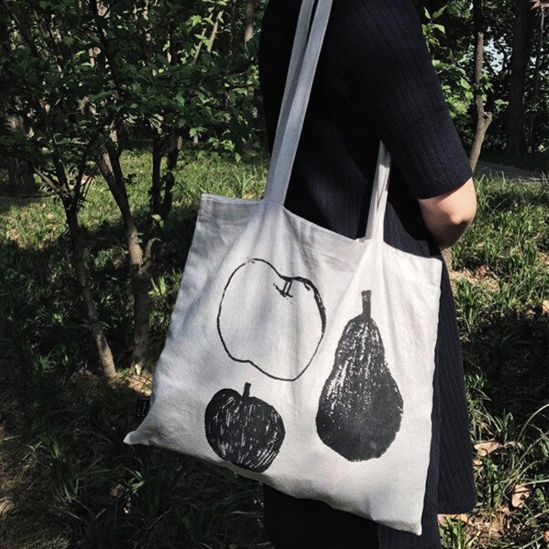 Close-up of vibrant fruit design featuring oranges and leaves on tote bag