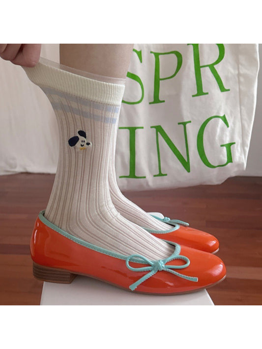Close-up of Rufia Playful Pup socks fabric with multicolored playful dog illustrations