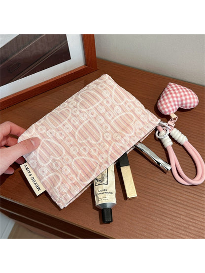 Cosbai heart print pouch held in hand to show size and portability