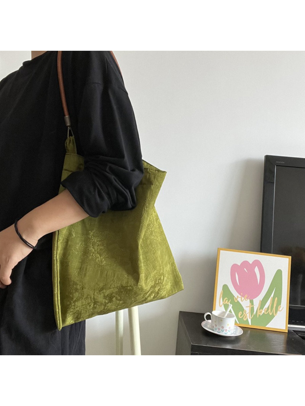 Close-up of handles and stitching detail on olive slouch tote