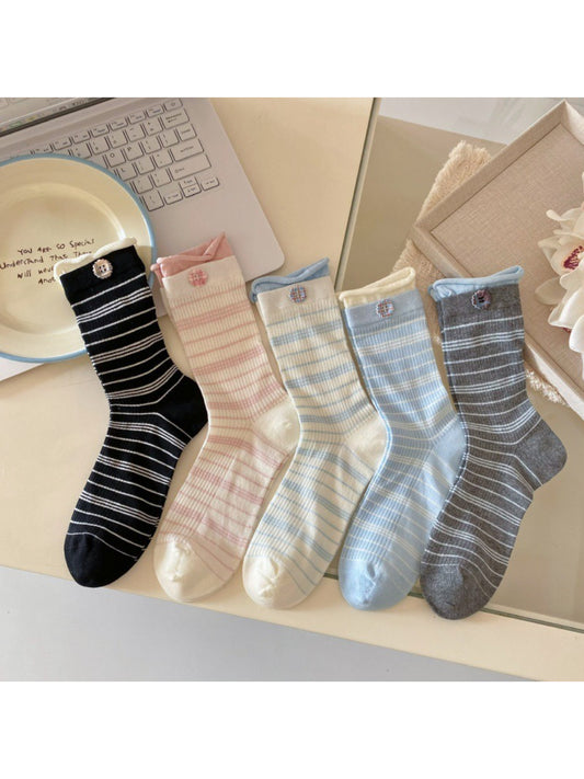 Pair of Rufia ribbed socks with buttons worn on feet, beige tone