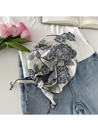 Scarvii neck scarf folded to display lace pattern and smooth fabric finish