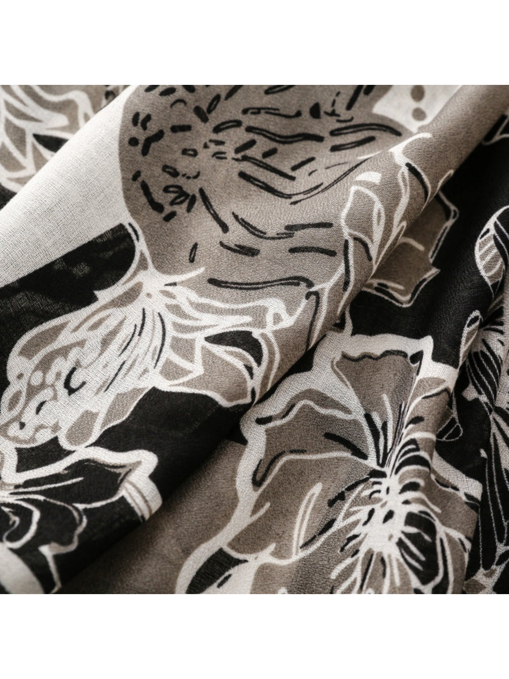 Close-up of outlined floral motifs across folds of the scarf