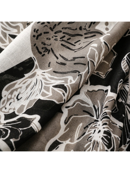 Close-up of outlined floral motifs across folds of the scarf