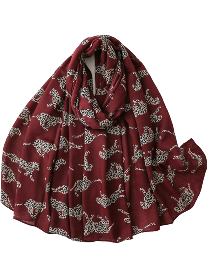 Burgundy scarf with repeating leopard silhouettes, loosely looped