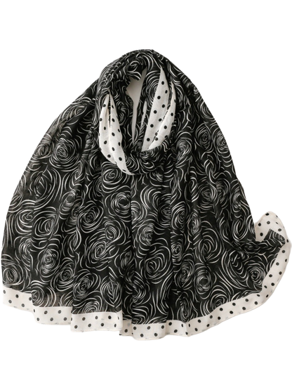 Black scarf with white rose motifs and a contrasting polka dot border, looped display