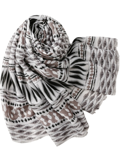 Scarf arranged in a loose coil, showing geometric bands and fringed ends