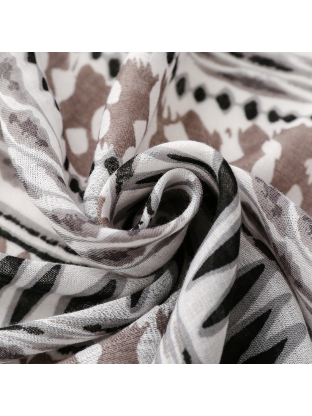 Close-up of scarf folds with black pointed shapes and taupe abstract motifs