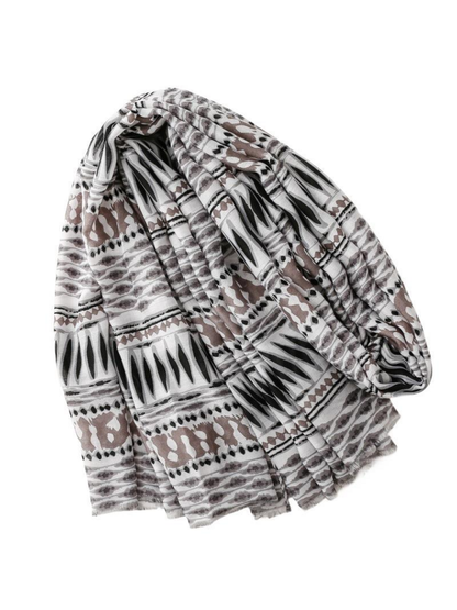 Scarf with black, gray and taupe geometric bands, draped on a white background