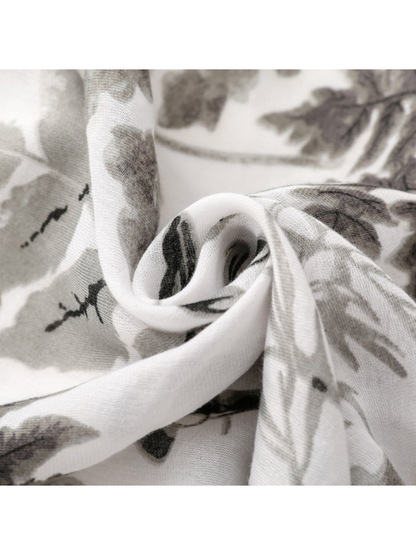 Close-up of Gray botanical print scarf showing fine woven texture and curled folds