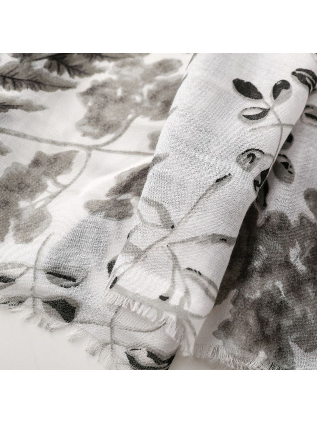 Close-up of Gray botanical print scarf with short fringed edges