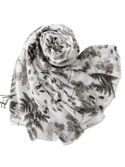 Gray botanical print scarf loosely rolled and draped with fringed edges