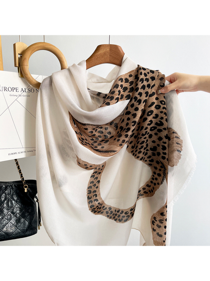 White scarf draped on a hanger, close-up of the spotted leopard motif