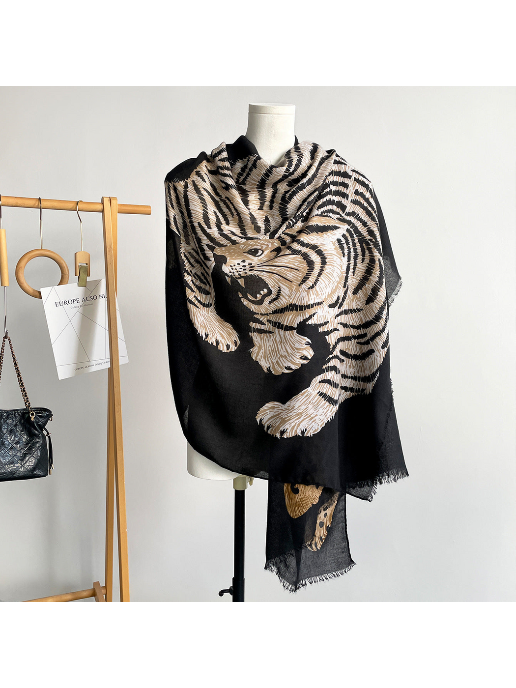 Black scarf draped on a mannequin with a large striped tiger and short fringe