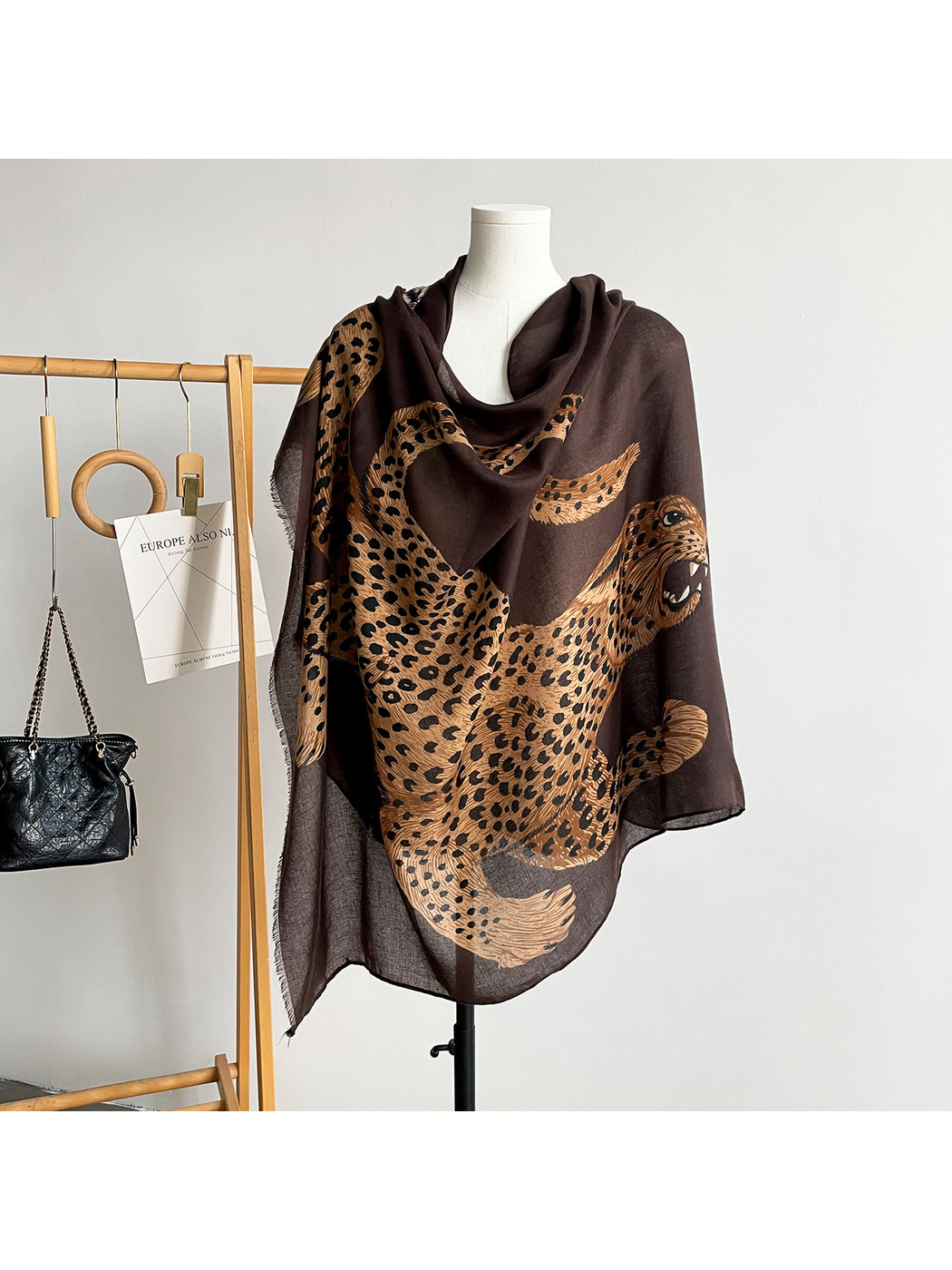 Brown scarf draped on a mannequin with a large spotted leopard motif