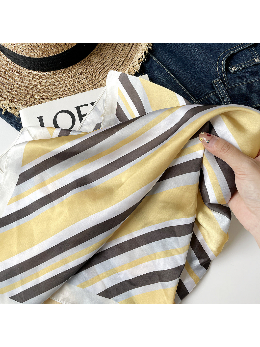 Close-up of diagonal yellow, dark and white scarf stripes gathered by hand