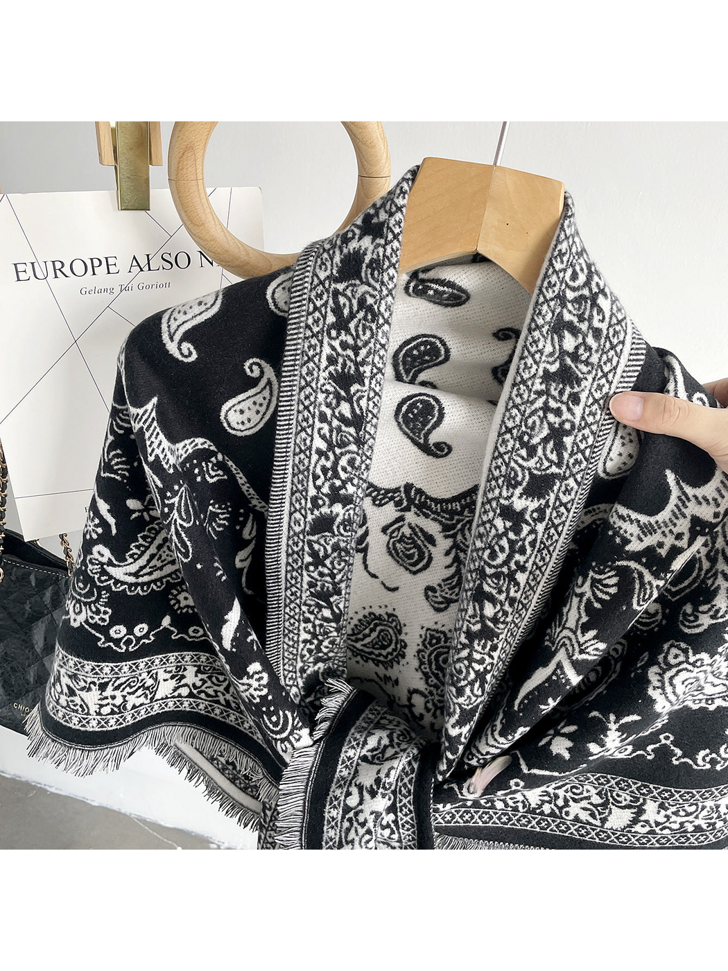 Black paisley scarf close-up showing contrasting faces, ornamental borders and fringe