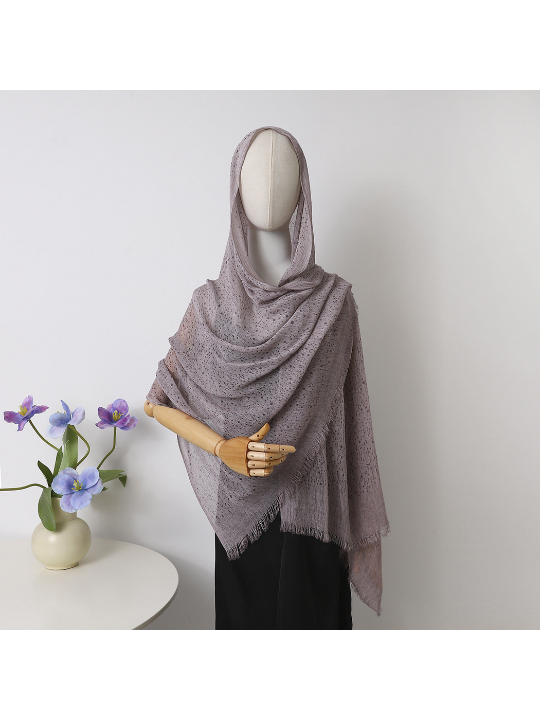 Purple openwork scarf with fringed edges draped over a mannequin