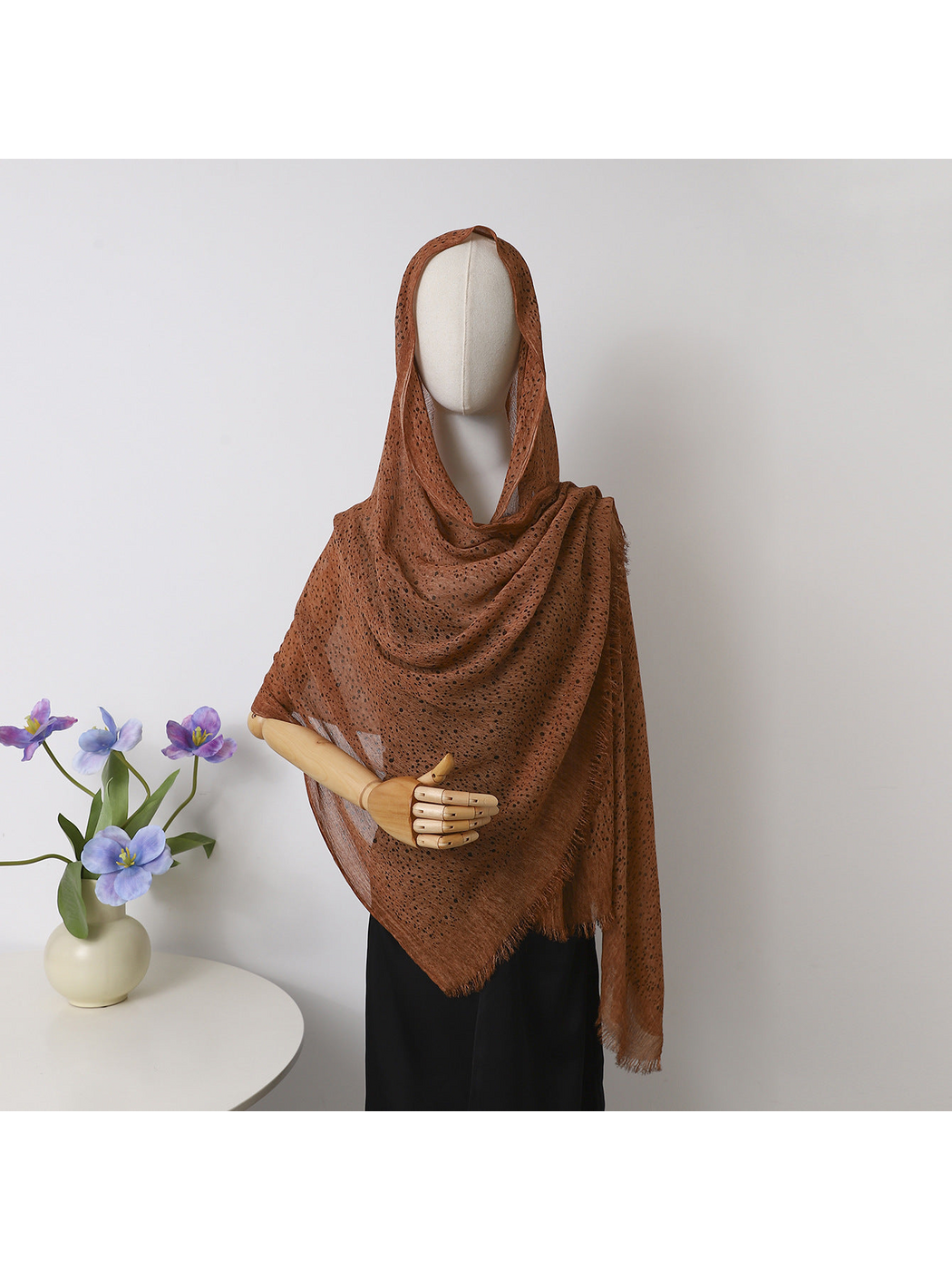 Caramel openwork scarf with fringed edges draped over a mannequin