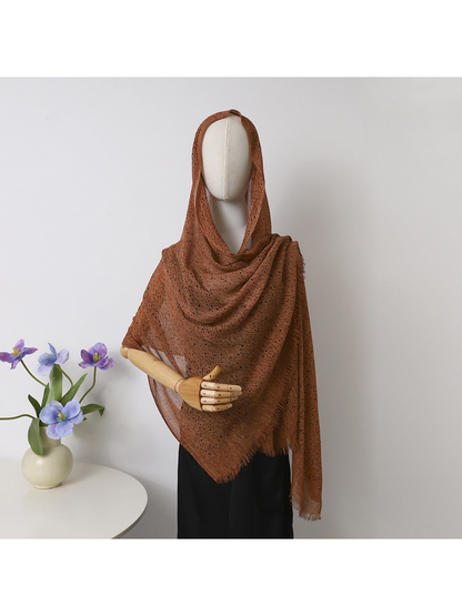 Caramel openwork scarf with fringed edges draped over a mannequin