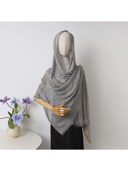 Gray openwork scarf with fringed edges draped over a mannequin