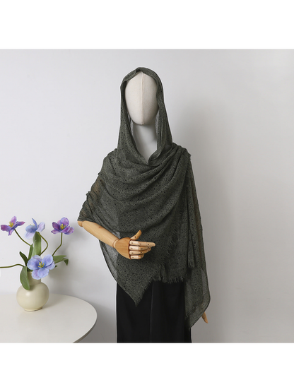 Green openwork scarf with fringed edges draped over a mannequin