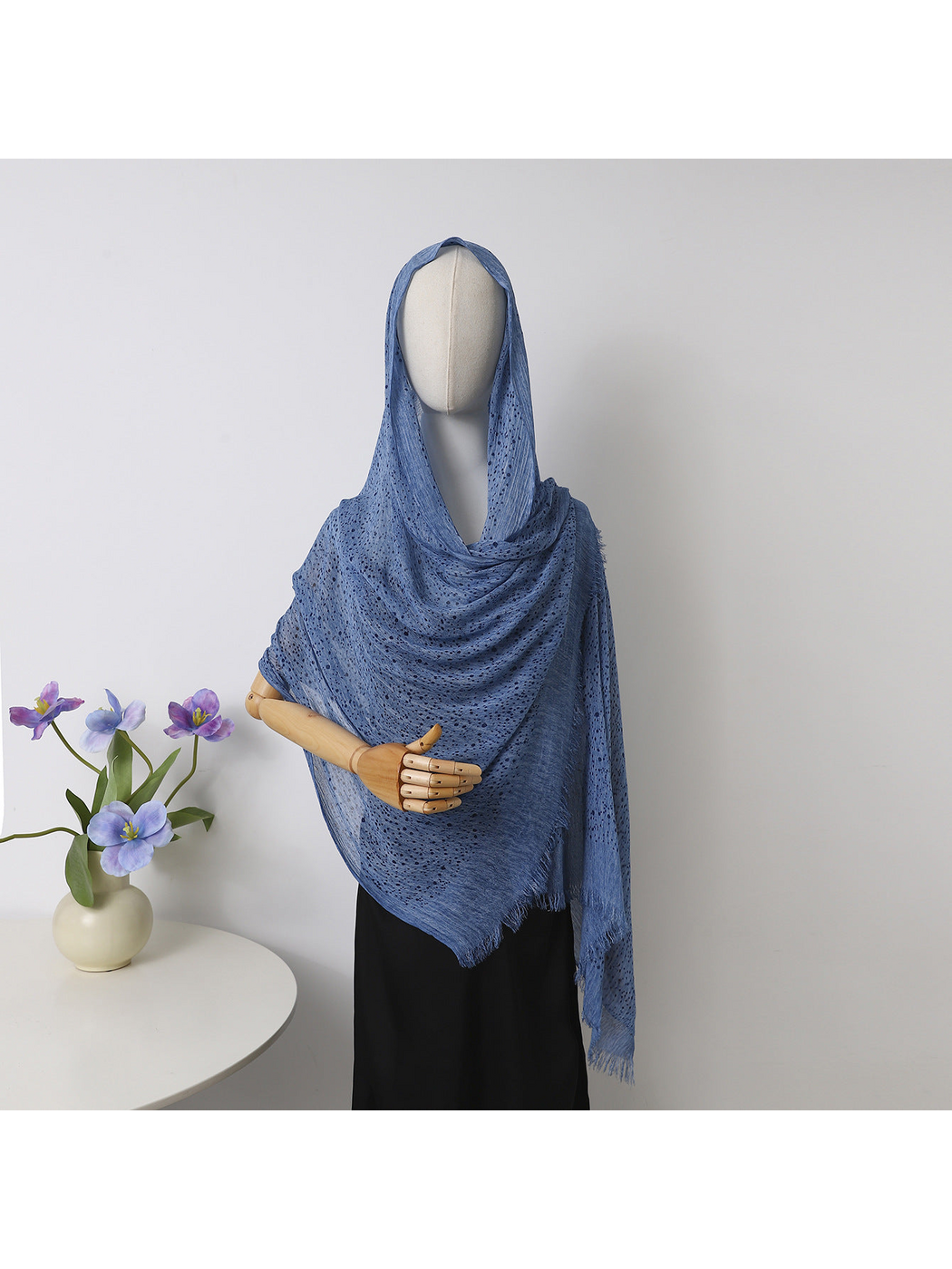 Blue openwork scarf with fringed edges draped over a mannequin