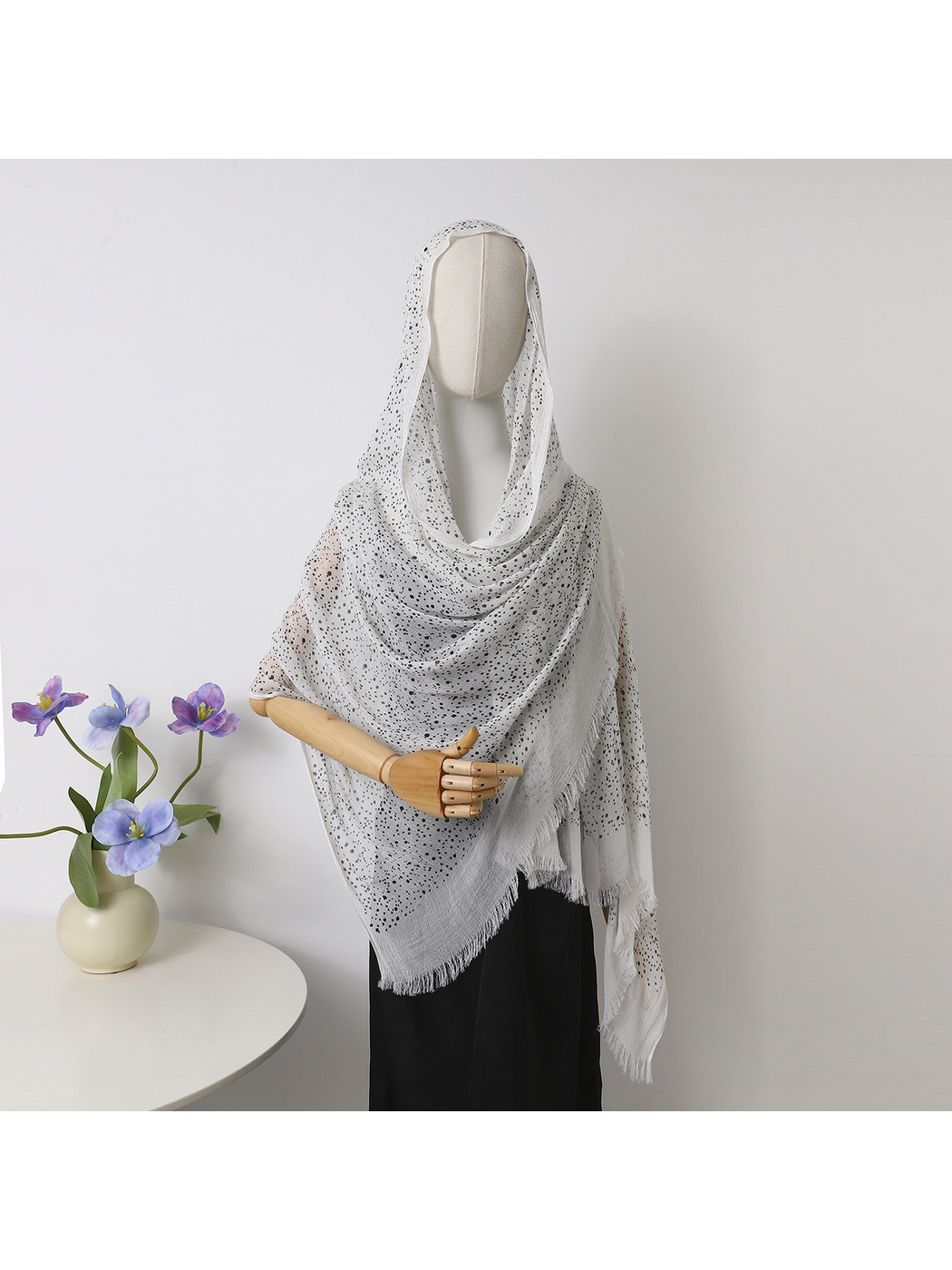 White openwork scarf with fringed edges draped over a mannequin