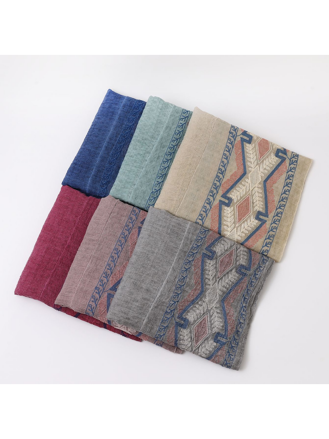 Six scarf colors folded together with geometric borders visible