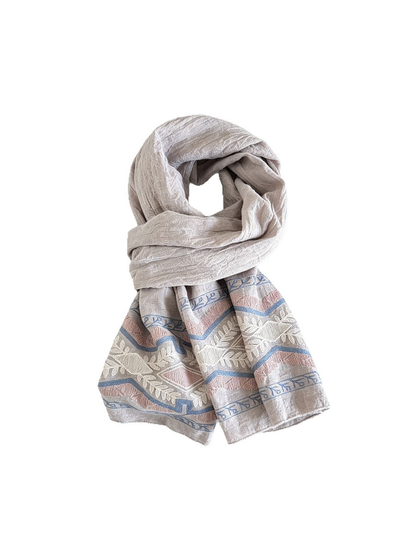 Light-colored scarf looped with geometric and leafy borders on both hanging ends