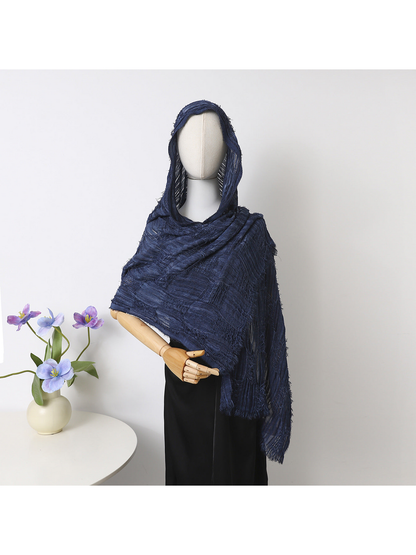 Navy scarf draped over a mannequin’s head and shoulders, showing openwork bands and fringed edges