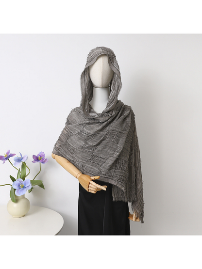 Gray scarf draped over a mannequin’s head and shoulders, showing openwork bands and fringed edges