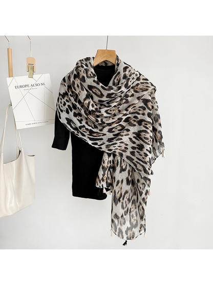 Multicolor leopard-print scarf with tassels draped asymmetrically over a black top
