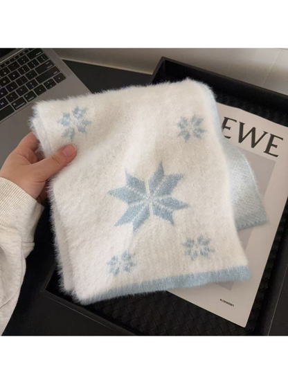 Blue scarf with snowflake motifs and contrasting border, held folded
