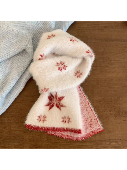 Red scarf with snowflake motifs and contrasting border, looped on a wooden table