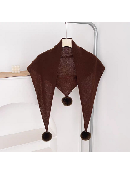 Brown knit triangle scarf hanging open with three pom-poms