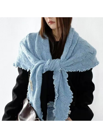 Blue knit scarf tied across the shoulders, with scalloped edges