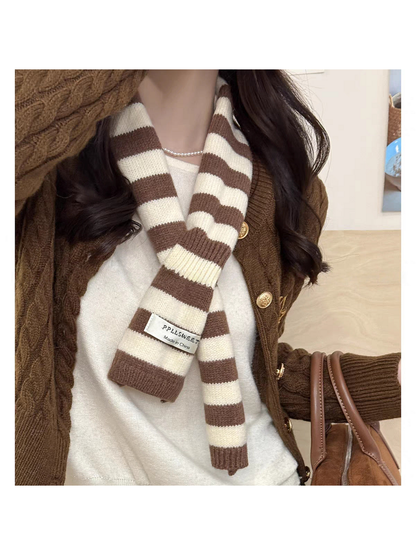 Brown striped knit scarf looped over a brown cardigan
